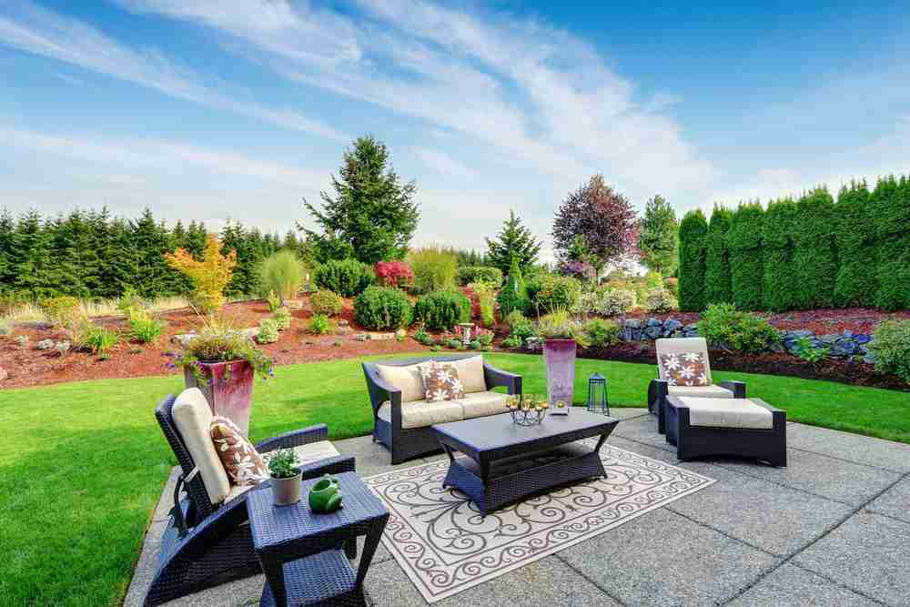 A closeup of a patio with several chairs and patio furniture surrounding it