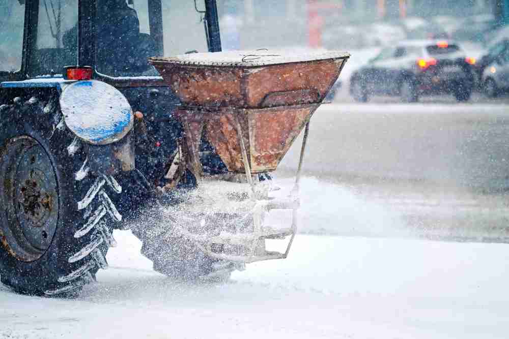 A tractor de-icing a road with road salt