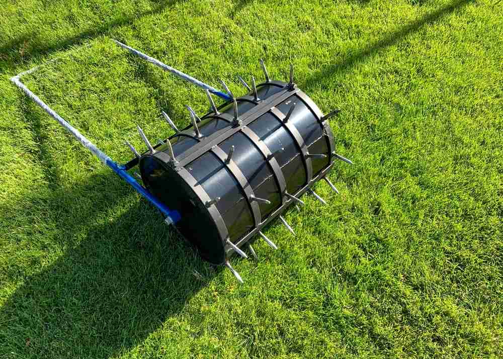 An up close view of a lawn aeration tool on a lawn