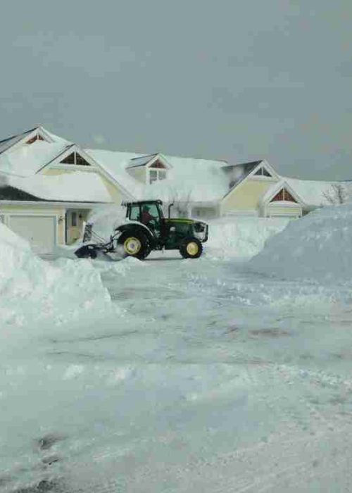 Tractor plowing large snowfall